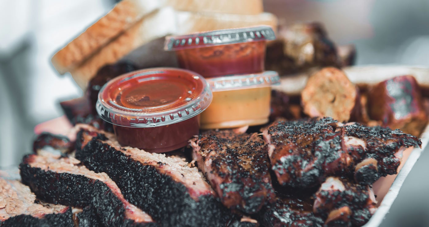 BBQ sauce containers on top of meat